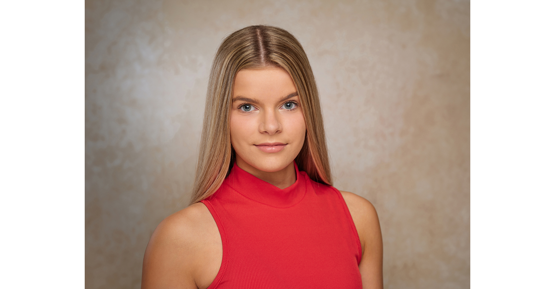 Blonde hair actress headshot in black leather jacket in front of canvas backdrop